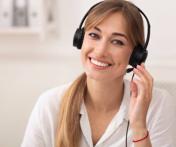 Smiling Woman In Headset Working In Call Center Office